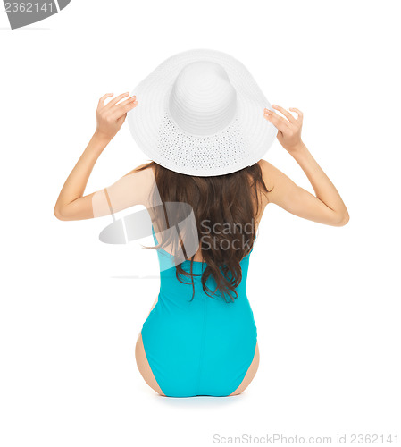 Image of model sitting in swimsuit with hat