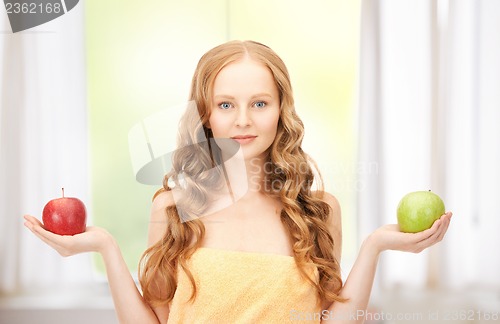 Image of young beautiful woman with green and red apples