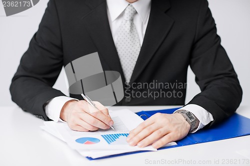 Image of businessman working and signing papers