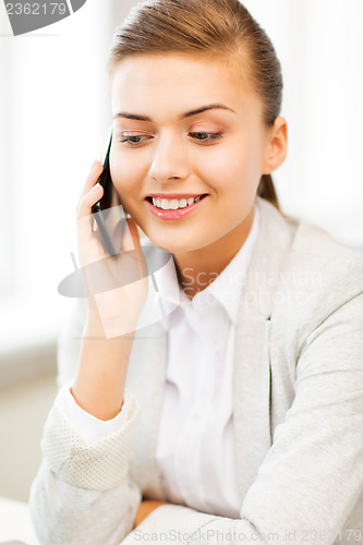 Image of businesswoman with smartphone in office