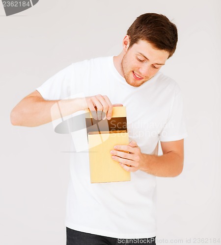 Image of man in white t-shirt with gift box