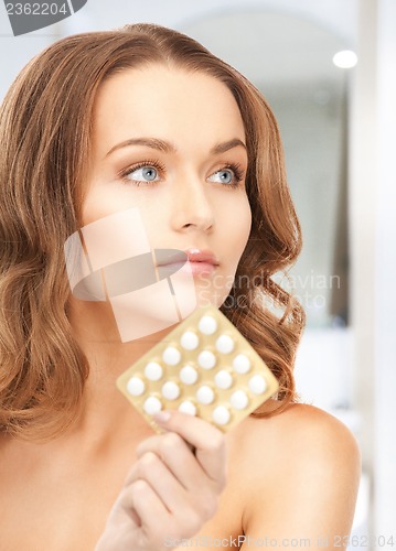 Image of young beautiful woman with pills