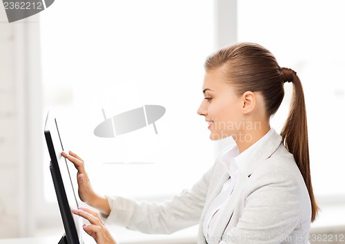 Image of smiling businesswoman with touchscreen in office