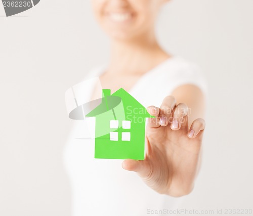 Image of woman hands holding green house