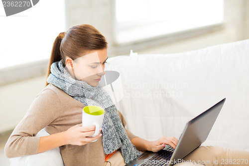 Image of diseased woman in scarf using laptop at home