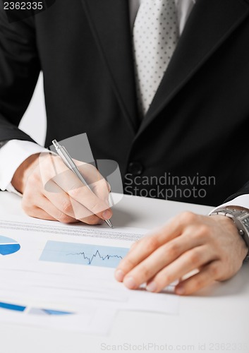 Image of businessman working and signing paper