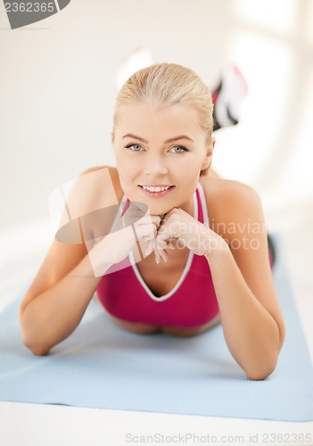 Image of sporty woman doing exercise on the floor