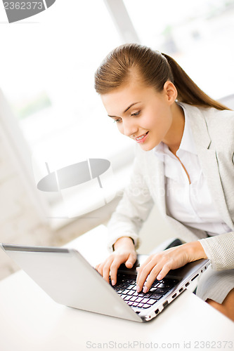 Image of businesswoman with laptop in office