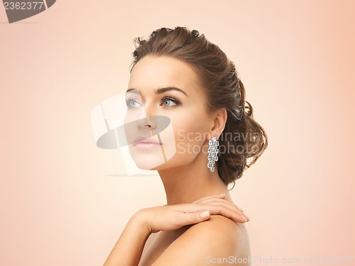 Image of woman wearing shiny diamond earrings