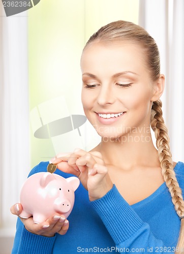 Image of lovely woman with piggy bank and money