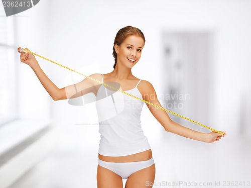 Image of young beautiful woman with measure tape