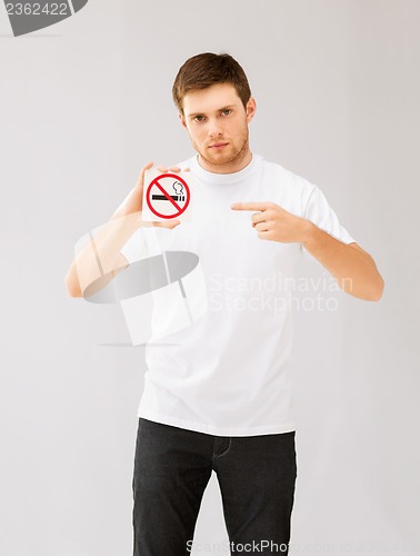 Image of young man pointing at no smoking sign