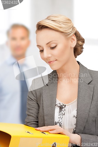 Image of young attractive businesswoman with folders
