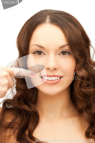 Image of woman pointing at her toothy smile