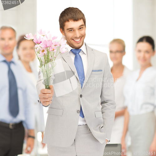 Image of handsome man with flowers in hand