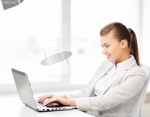Image of businesswoman with laptop in office