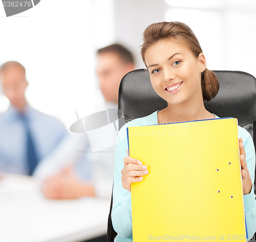 Image of young attractive businesswoman with folders