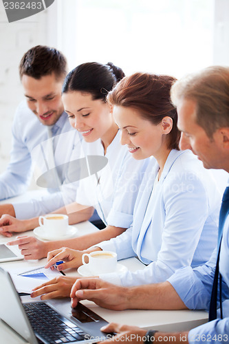 Image of group of people working with laptops in office