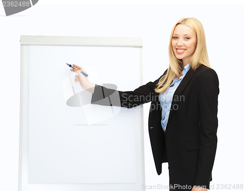 Image of businesswoman writing on flipchart in office