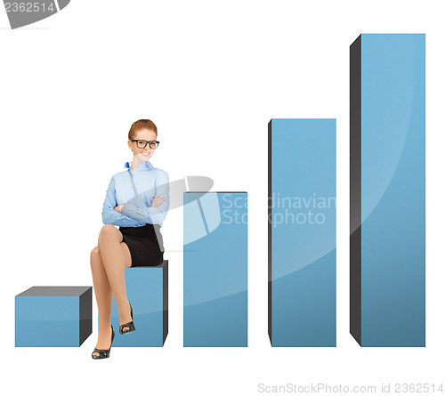 Image of businesswoman sitting on big 3d chart