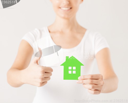 Image of woman hands holding green house