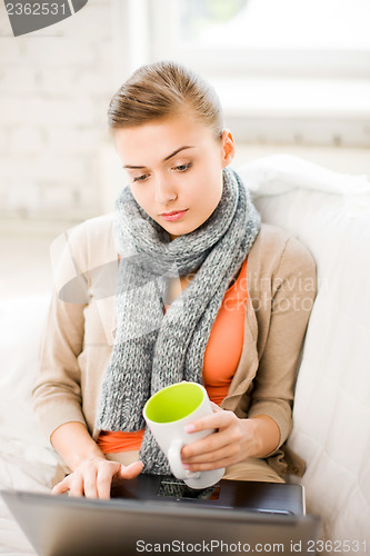 Image of diseased woman in scarf using laptop at home