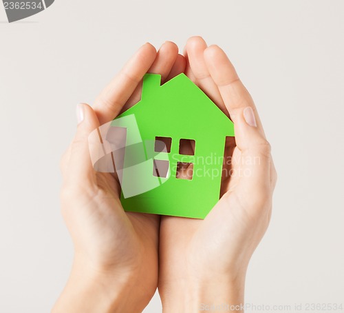 Image of hands holding green house