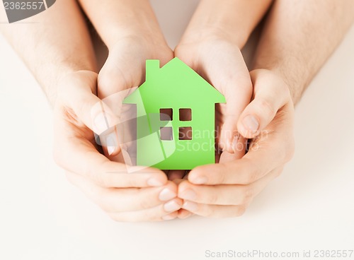 Image of couple hands holding green house