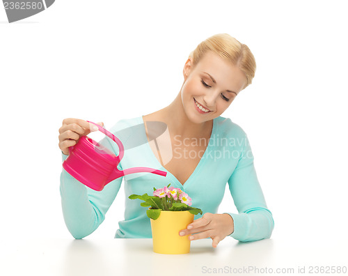 Image of housewife with flower in pot and watering can