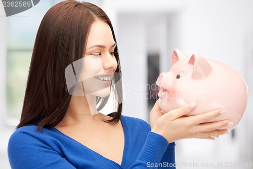 Image of lovely woman with piggy bank