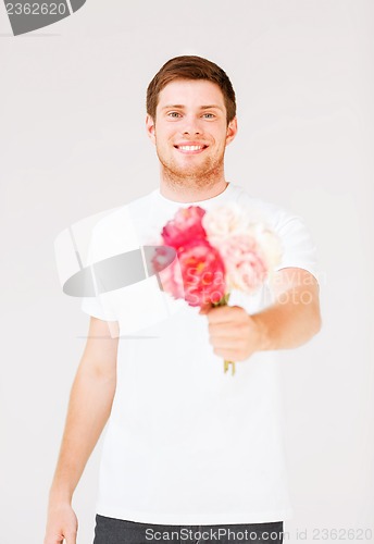 Image of young man holding bouquet of flowers