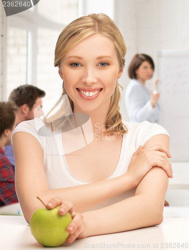 Image of beautiful girl with green apple at school