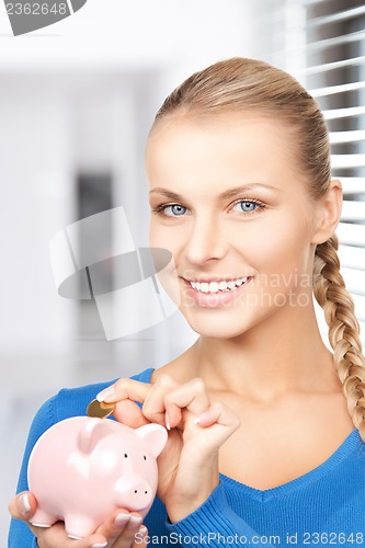 Image of lovely woman with piggy bank and money