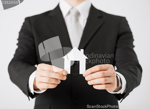 Image of man hands holding paper house