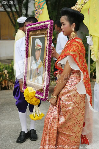 Image of Thai youth holding a photograph of the King during in a parade,