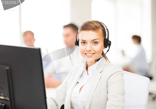 Image of helpline operator with headphones in call centre