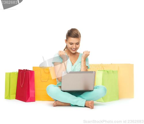 Image of woman with laptop and shopping bags