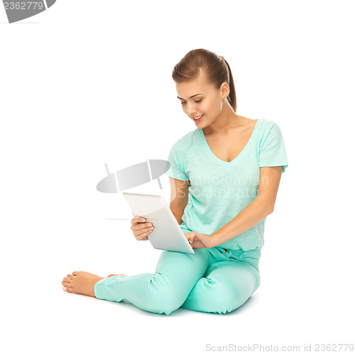 Image of young girl sitting on the floor with tablet pc