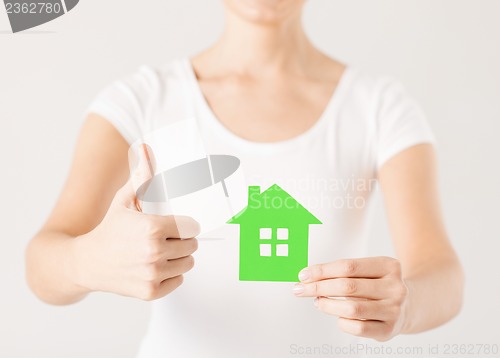 Image of woman hands holding green house