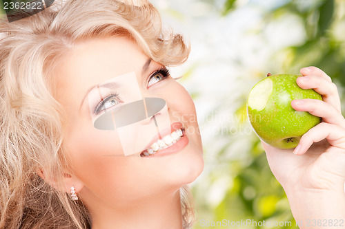 Image of young beautiful woman with green apple