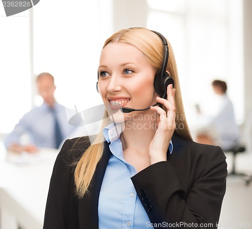 Image of helpline operator with headphones in call centre