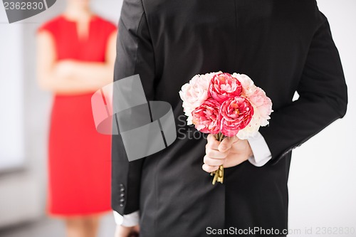 Image of man hiding bouquet of flowers