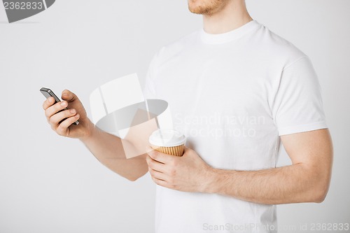 Image of man with smartphone and coffee