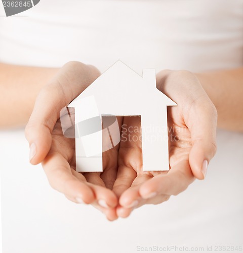 Image of woman hands holding paper house