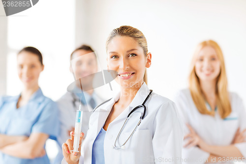 Image of female doctor holding syringe with injection