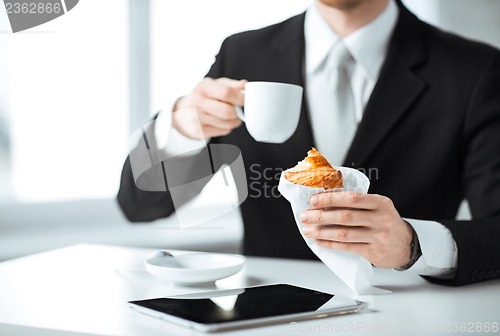 Image of man with tablet pc and cup of coffee