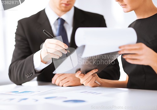 Image of businessman and businesswoman signing paper