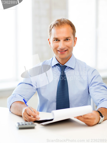 Image of businessman with notebook and calculator