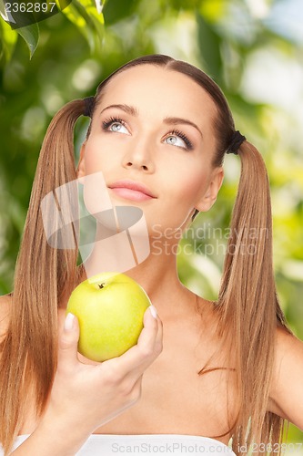 Image of young beautiful woman with green apple