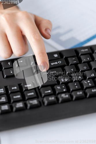 Image of woman hand pressing enter button on keyboard